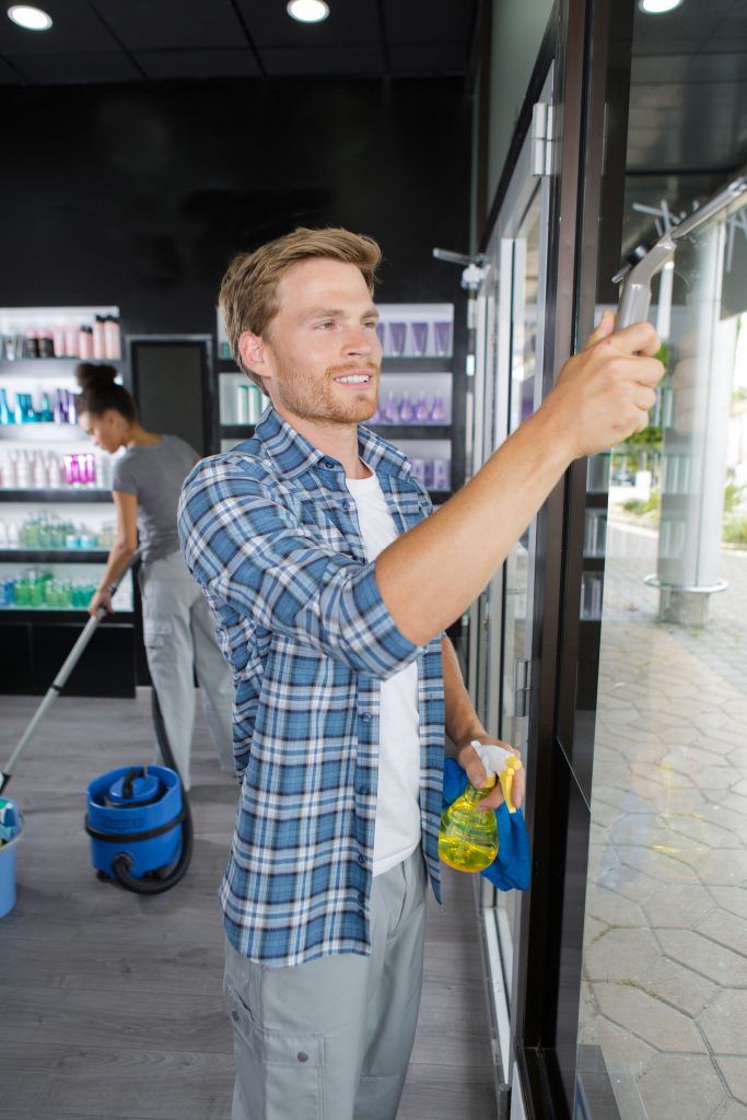 window cleaner scraping glass in building